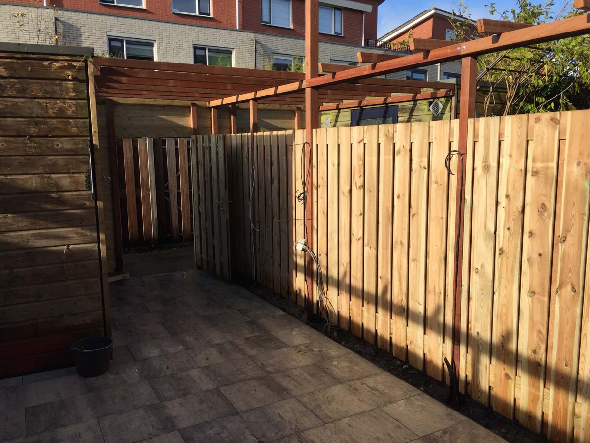 Schutting met een pergola erop