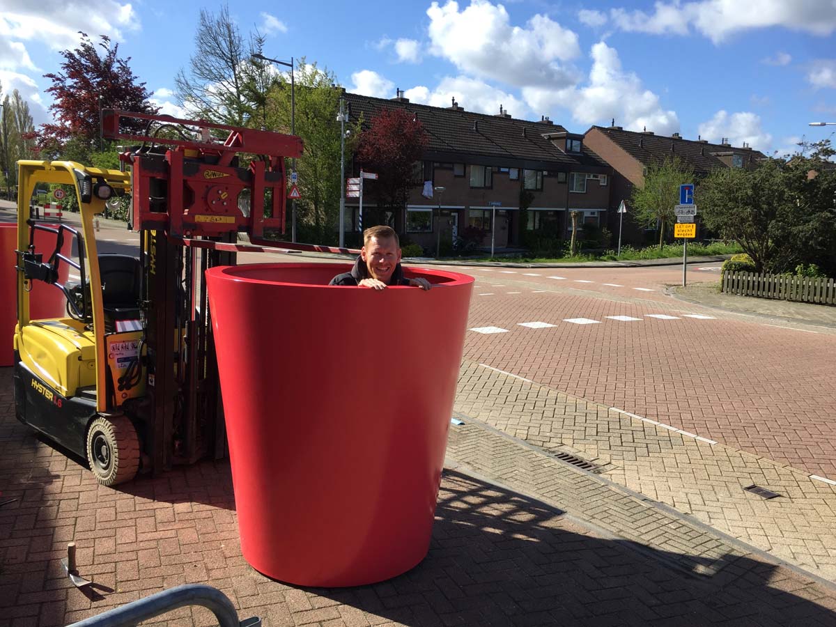 Een grote pot wordt met een heftruck geplaatst