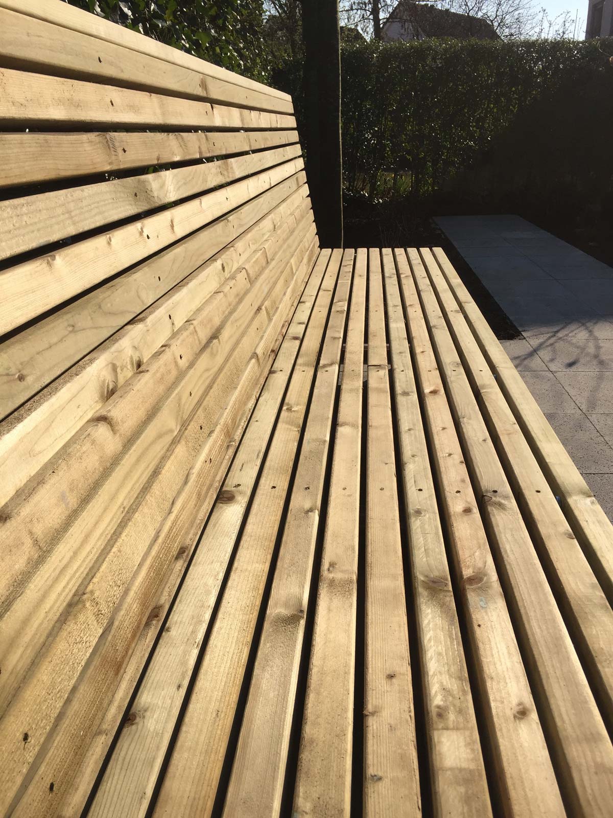 Vaste houten bank tegen een schutting van horizontale planken