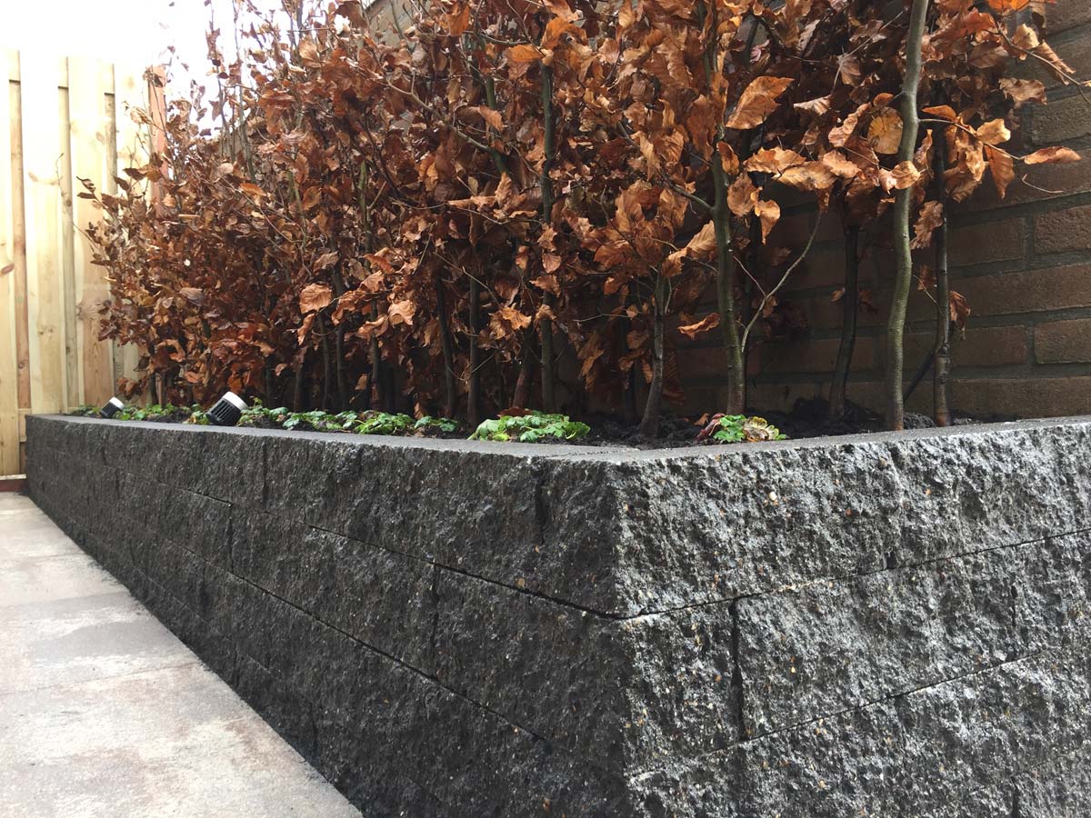 Hoek van een granieten border met beplanting