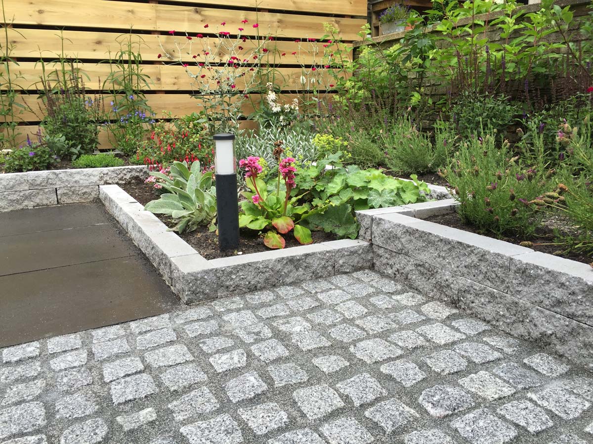 Verhoogde border van graniet met beplanting