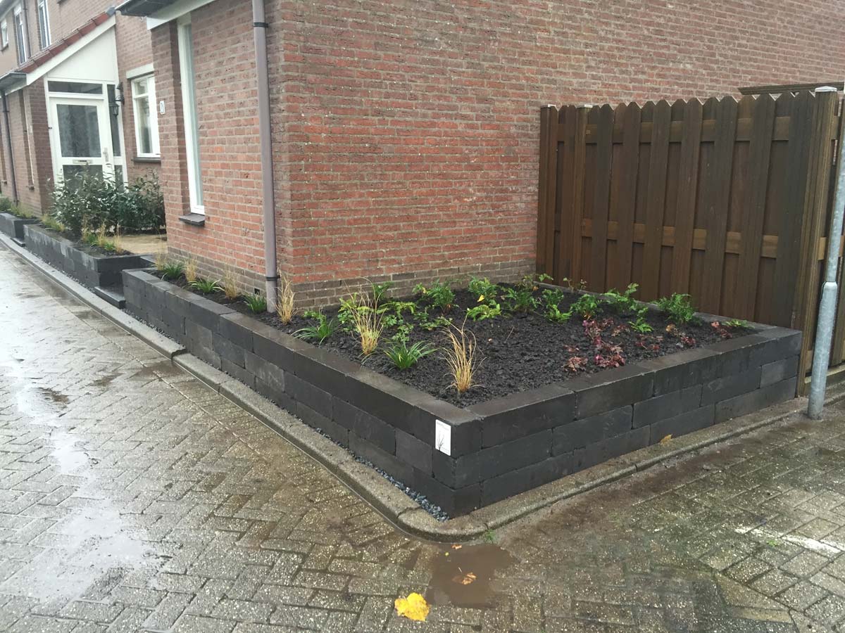 Lage keerwand langs een tuinpad