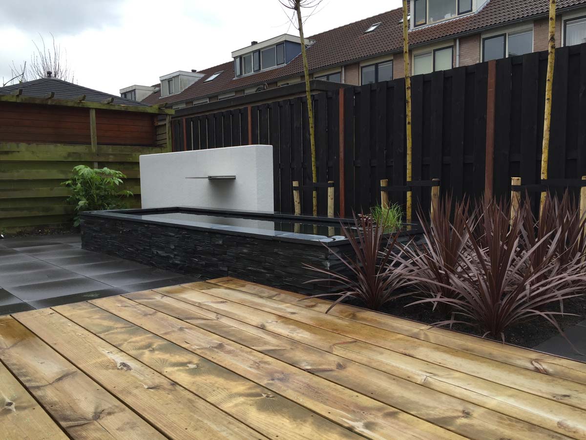 Vlonder met beplanting en donkere erfafscheiding
